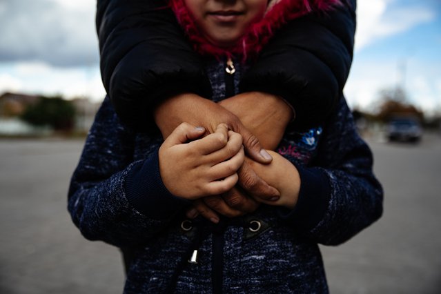 Alla uit Oekraïne slaat haar armen om haar dochter. Het meisje krijgt medische hulp in onze mobiele kliniek in Donetsk. © Hussein Amri/MSF