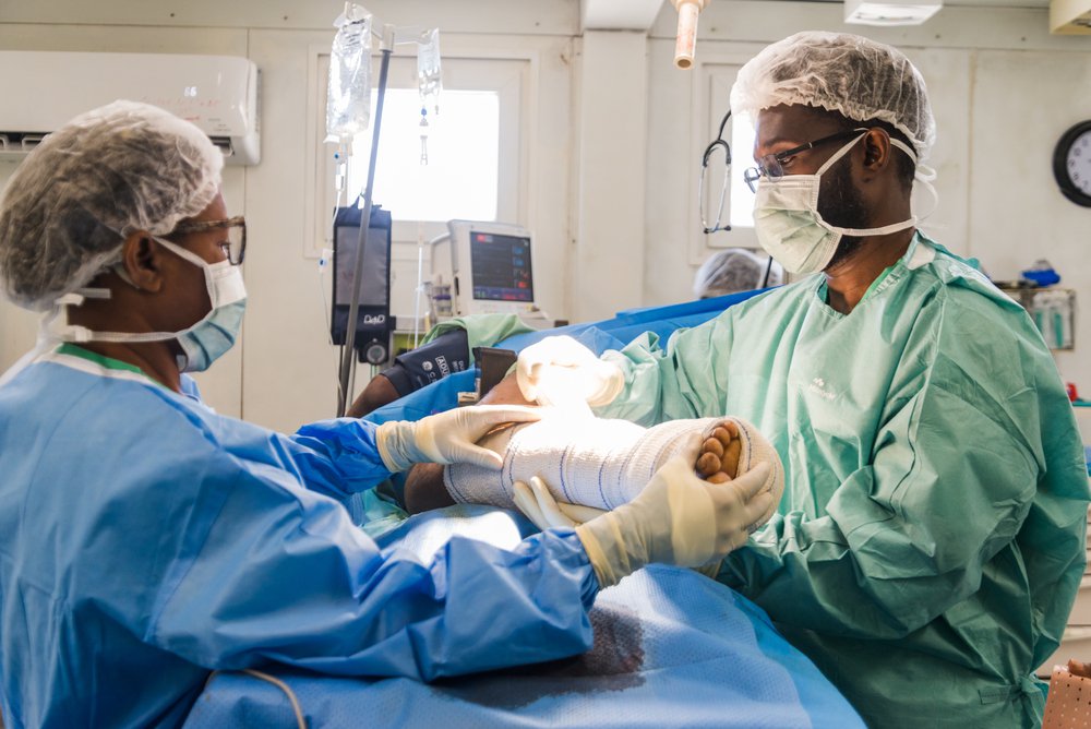 Een patiënt met een schotwond wordt behandeld in de operatiekamer van ons ziekenhuis in Port-au-Prince. Haïti, 19 maart 2024. © Réginald Louissaint Jr