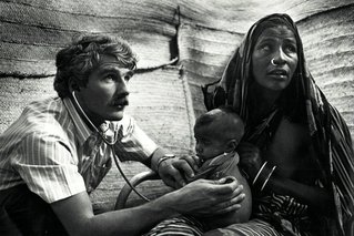 Dr. Francis Charhon onderzoekt het kind van een jonge vrouw in kamp Faw. © Sebastiao Salgado
